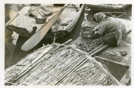[Woman working on boat]